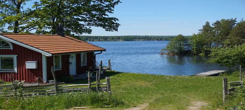 Ein rotes Holzferienhaus direkt am See