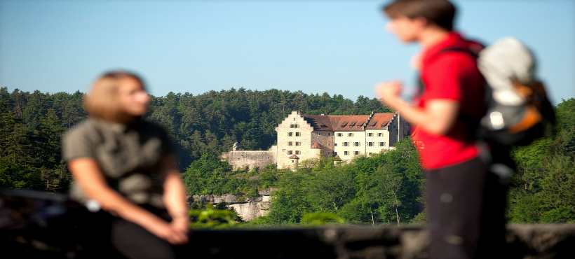 Ein Mann und eine Frau mit einer Burg im Hintergrund