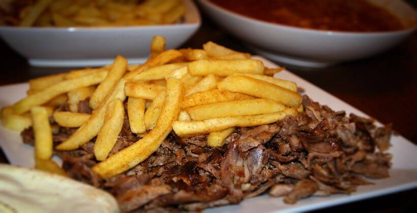 Fleischscheiben ähnlich wie bei einem Kebab mit Pommes oben drauf