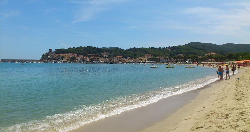 Sandstrand von Elba wo es sich einige Touristen bequem gemacht haben.