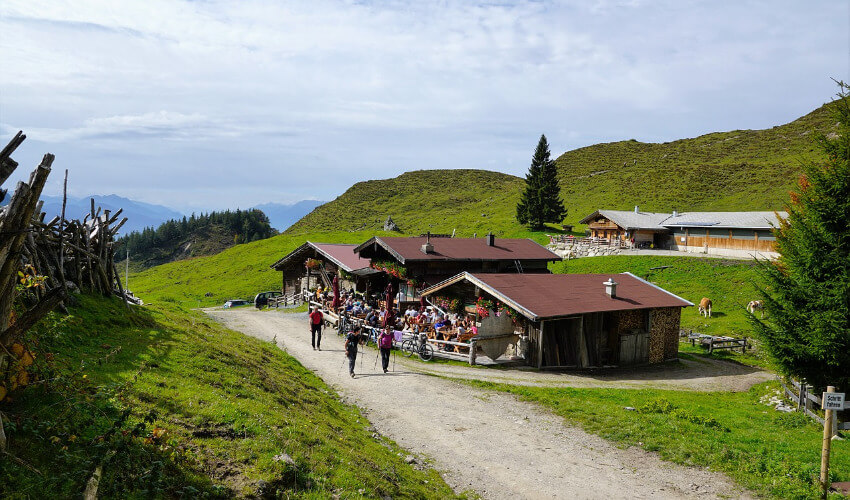 Eine Almhütte in den Bergen von Salzburg, wo sich einige Wanderer erholen.