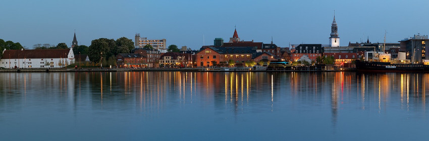 Das belebte Uferviertel von Aalborg bei Abenddämmerung.