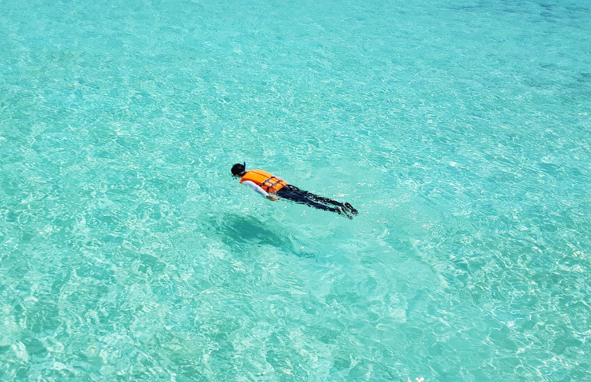 Ein Schnorchler auf dem saubern türkisen Meer der Malediven.