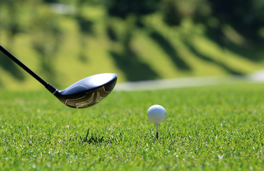 Ein Golfball auf einem Holz Tees liegt zum Abschlag bereit.