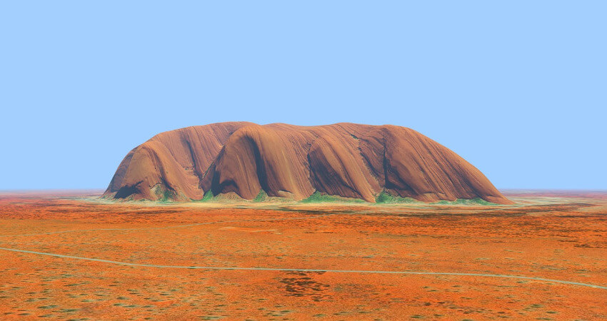 Ein riesiger Fels aus Akrose-Sandstein mitten in der Wüste Australiens.