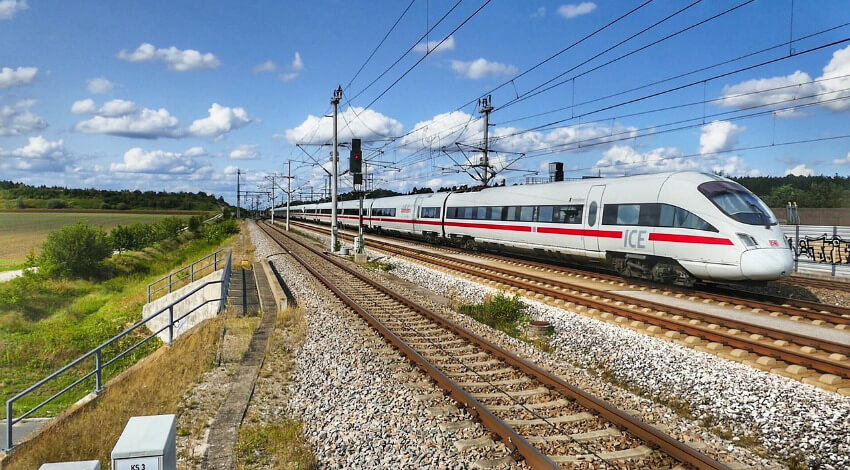 Ein ICE der Deutschen Bahn während der Fahrt an einem schönen Frühlingstag.