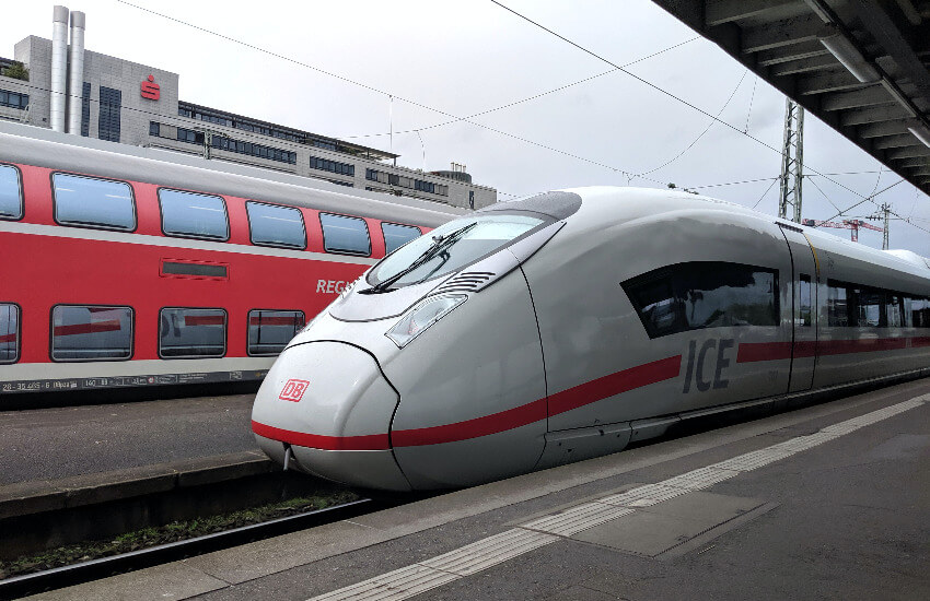 Ein ICE der Deutschen Bahn steht am Bahnsteig, dahinter ein Doppelstock Regionalexpress.