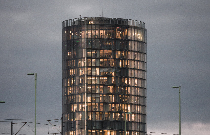 Ein beleuchteter Büroturm in der Abenddämmerung.