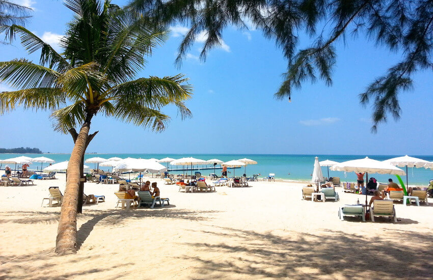 Ein Sandstrand mit Palmen und liegen bei traumhaften Wetter.