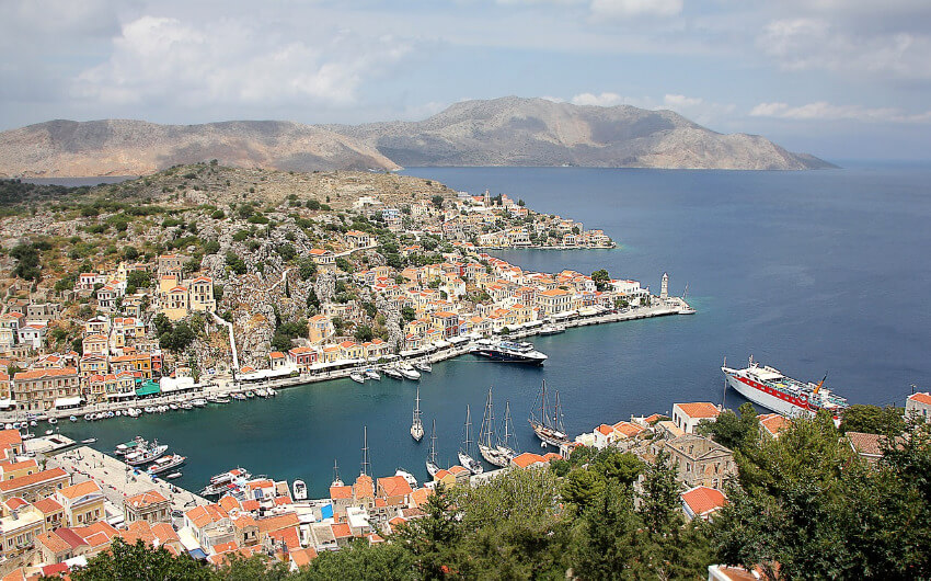 Hafen Symi umgeben von schönen griechischen Häusern.