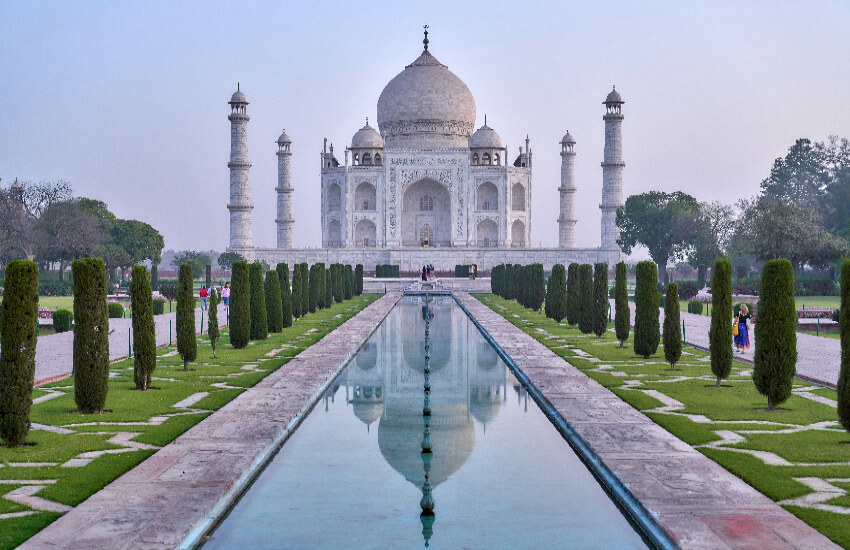 Wunderschönes Taj Mahal in Agra, Indien, mit Spiegelung im Wasserbecken bei Sonnenaufgang.