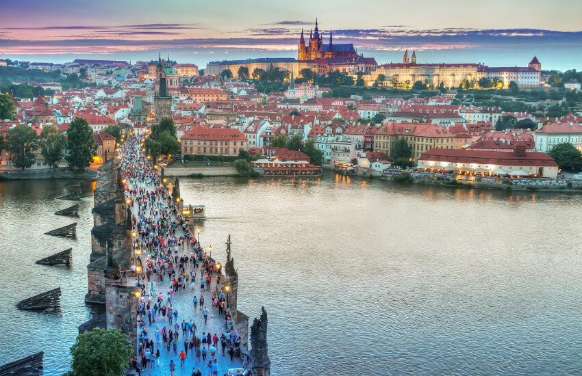 Karlsbrücke in Prag Ansicht der Karlsbrücke über die Moldau in Prag mit vielen Menschen, die sie überqueren. Im Hintergrund historische Gebäude.
